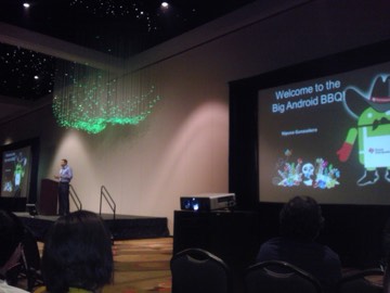 A keynote slide reading 'Welcome to the Big Android BBQ' under a green fiber-optic chandelier.
