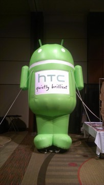 A giant inflatable green Android wearing an 'HTC quietly brilliant' sign.