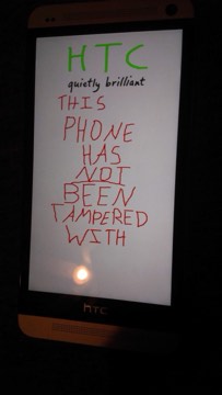 A handwritten custom boot splash on an HTC One reading 'this phone has not been tampered with'.
