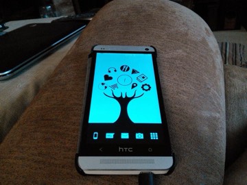 An HTC One showing a custom tree-of-apps home screen theme.